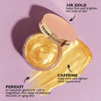 Gold facial mask in clear jar with cream lid, shown with swatches of golden gel texture on pink background.