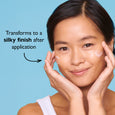 Person with hands on cheeks displaying smooth, glossy skin texture against a blue background.