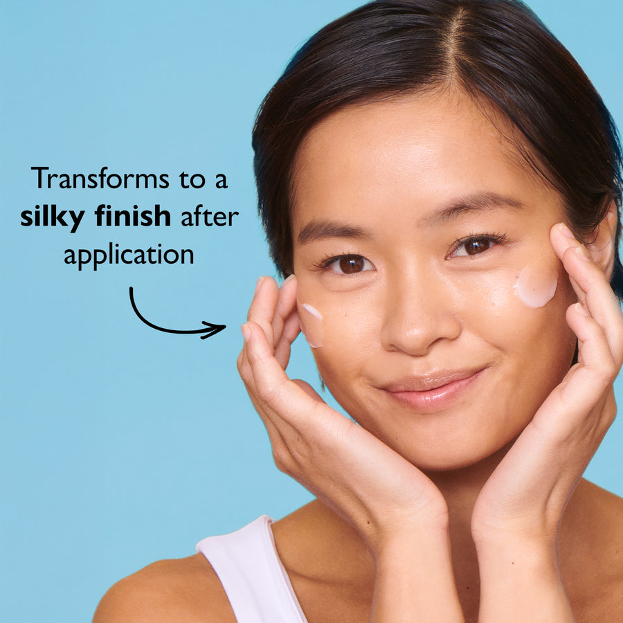 Person with hands on cheeks displaying smooth, glossy skin texture against a blue background.