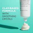 White tube of microdermabrasion exfoliator with product swatches on turquoise background, labeled 50 ml / 1.7 fl oz.