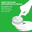 Hand pressing plastic disc down on jar of eye patches with instruction text on green background.