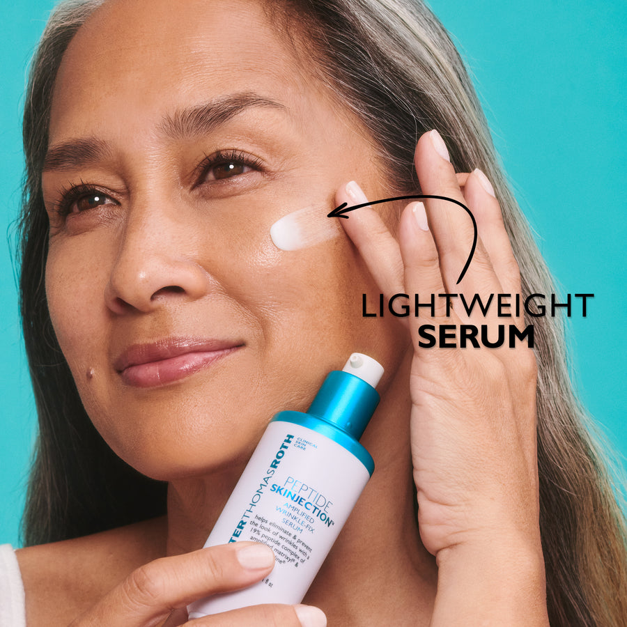 White serum bottle with blue cap held next to woman's face showing product application on cheek against turquoise background.