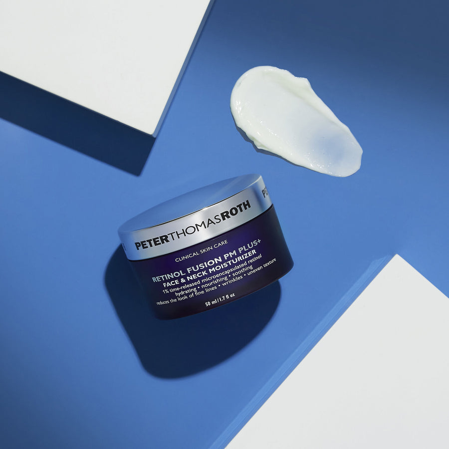 Dark jar of Peter Thomas Roth Retinol Fusion PM Plus+ moisturizer with white cream swatch above on blue background.