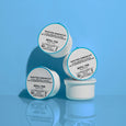 Four white refill pods with turquoise lids labeled Water Drench Hyaluronic Cloud Rich Barrier Moisturizer against a blue back