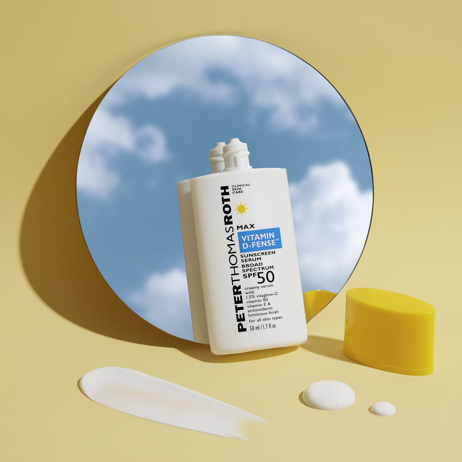 White bottle of Max Vitamin D-Fense sunscreen serum SPF 50 displayed with product swatches and yellow geometric shapes agains