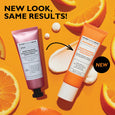 Orange tube of Potent-C Niacinamide Discoloration Treatment with cream swatches on yellow background with citrus slices.