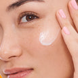 Clear gel serum applied to cheek of person with fair skin and pink nail polish.