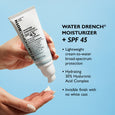 White tube of Water Drench SPF 45 moisturizer held in hand against blue background with product texture shown below.