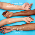 Four arms displaying moisturizer swatches on different skin tones against a blue background.