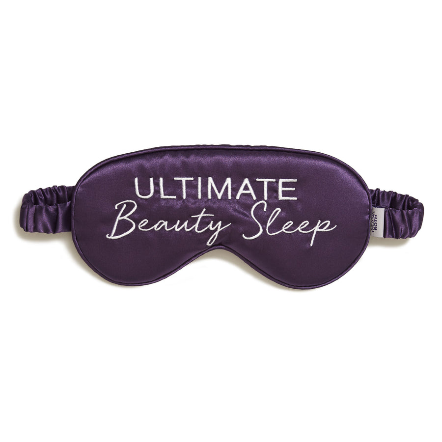 Purple silk eye mask with "Ultimate Beauty Sleep" text and adjustable elastic straps.