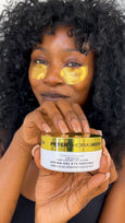 Person wearing yellow gel eye patches holding a Peter Thomas Roth 24K Gold Hydra-Gel Eye Patches container.