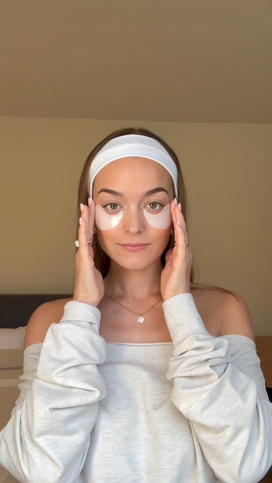Person wearing white eye patches under both eyes with a white headband and white long-sleeved top.